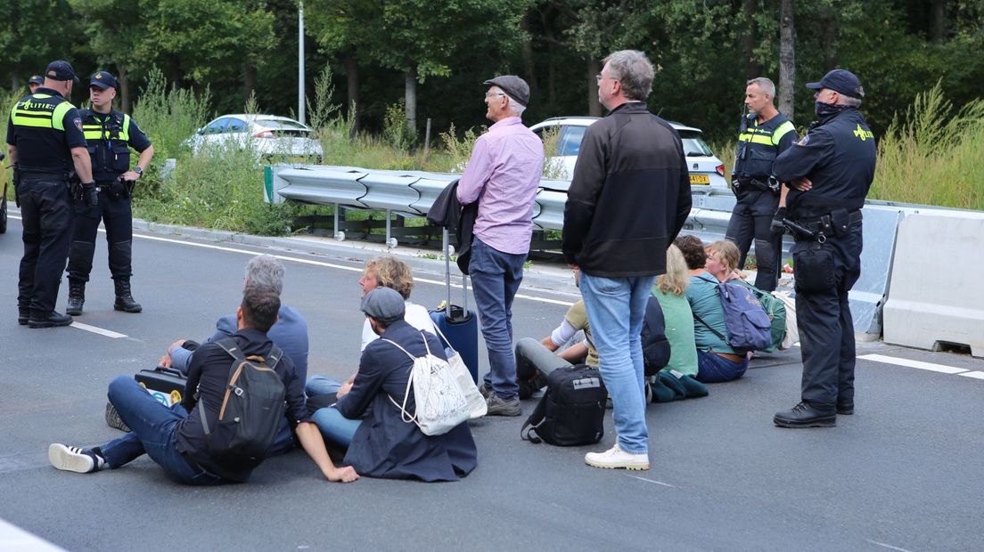 De actievoerders zitten midden op de snelweg