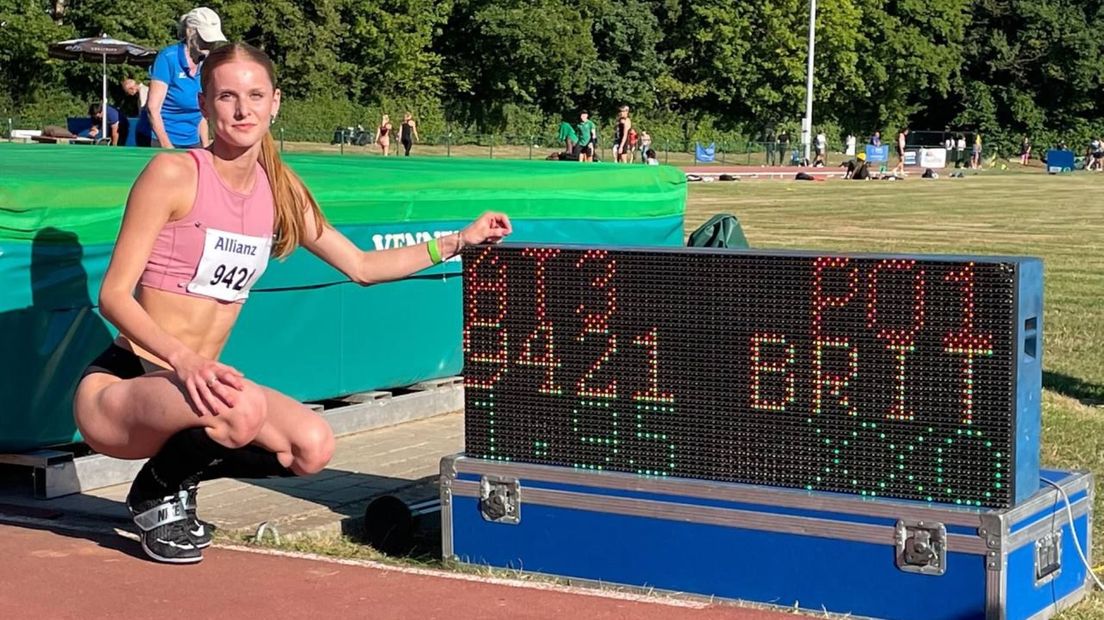 Een trotse Britt Weerman poseert bij het scorebord