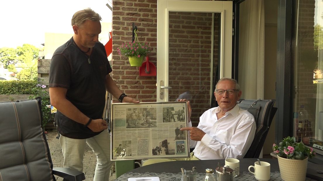 Henk Terink en zijn zoon bekijken een publicatie van het boek.