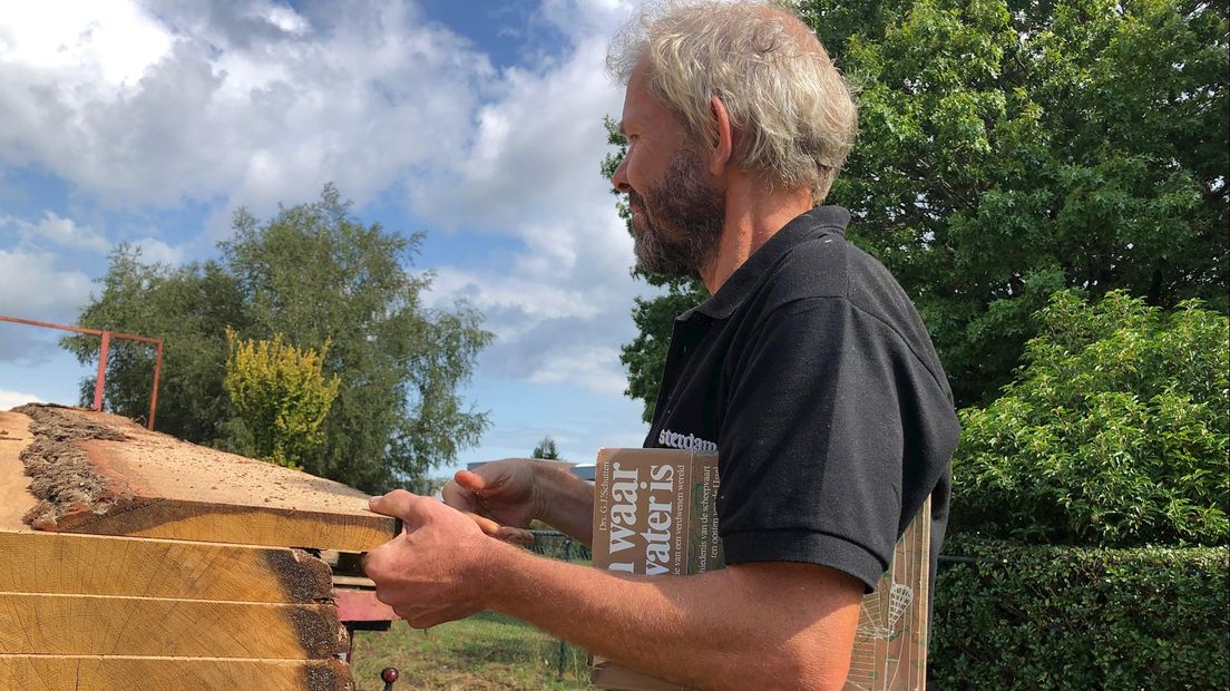 Timmerman met de 'bouwbijbel' onder zijn arm