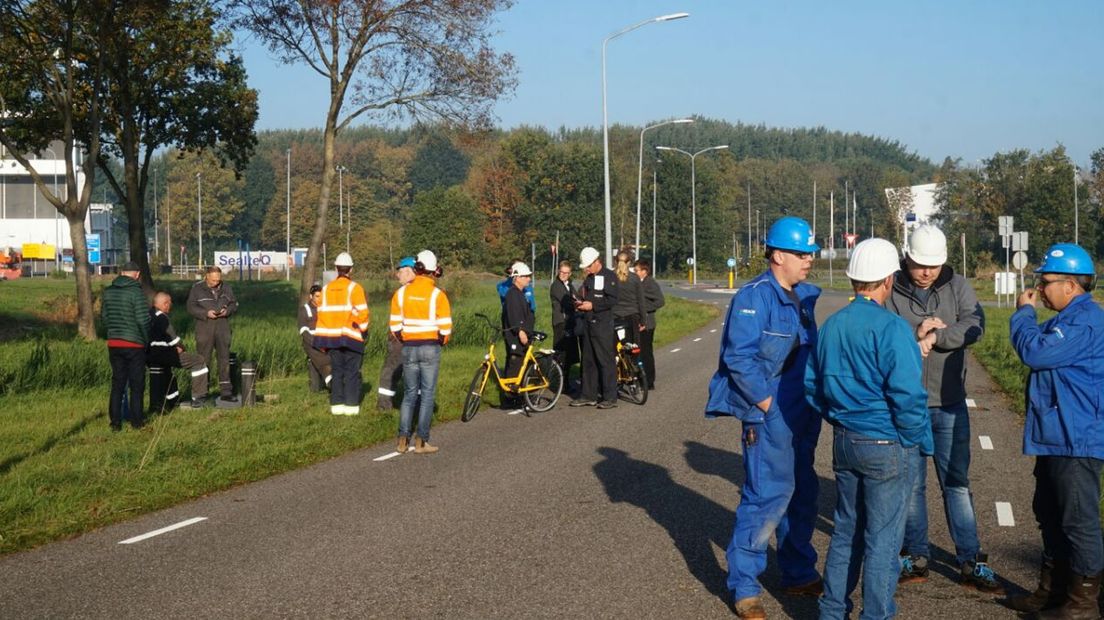 Personeel van omliggende bedrijven staat buiten na het lek