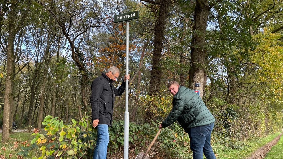 Wethouder Robert Meijer verstevigt het eerste straatnaambordje van de Oosterduinen.