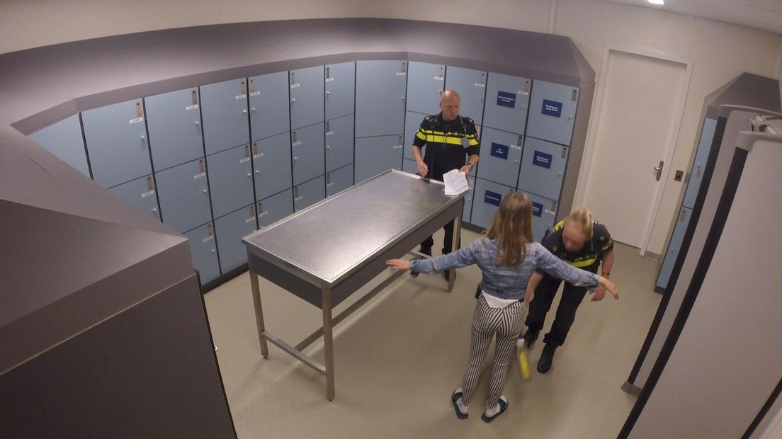 Een minderjarige verdachte wordt gefouilleerd