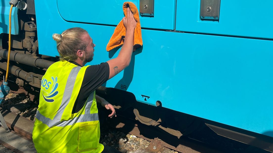 Job Schut poetst een trein schoon