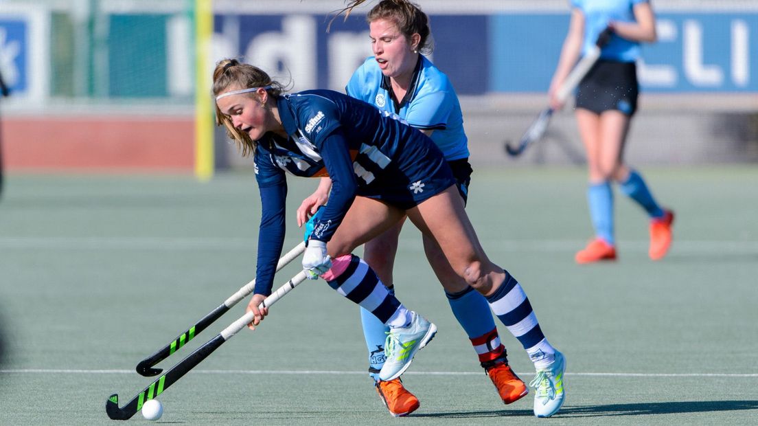 Jip Dicke van HDM in duel met Lisa Harteveld van HGC