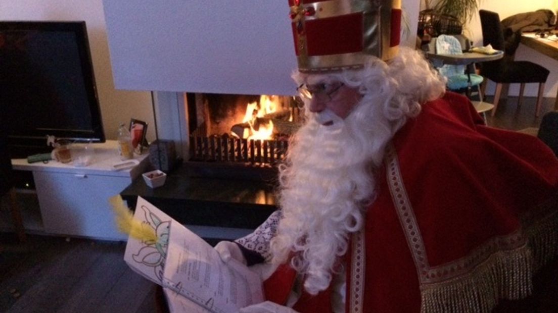Sinterklaas kijkt in zijn grote boek