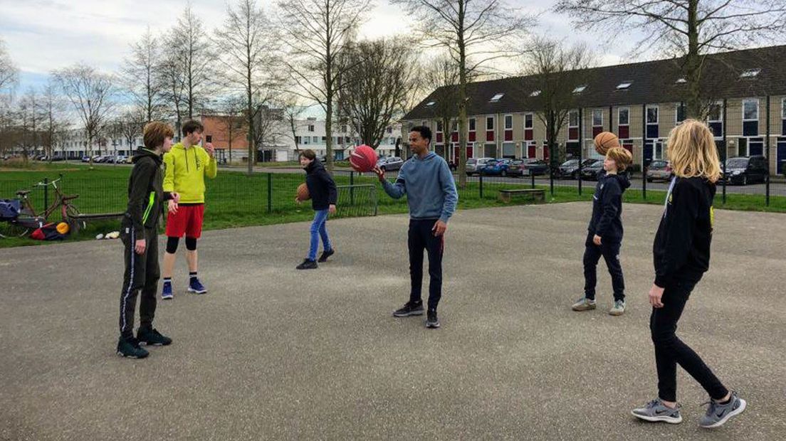 Jongeren op het basketbalpleintje in de wijk Hoornse Meer in Stad
