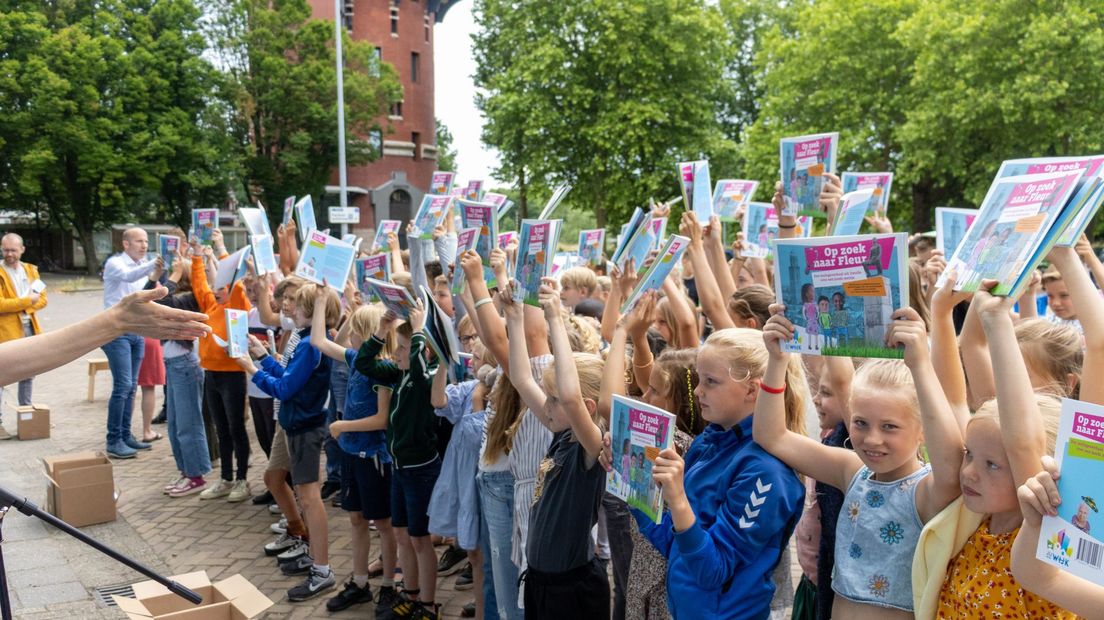 De driehonderd schrijvers en tekenaars houden hun boek trots omhoog.