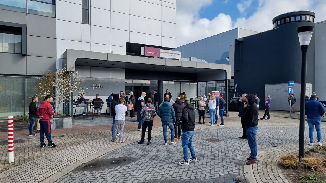 Mensen staan buiten het hotel te wachten