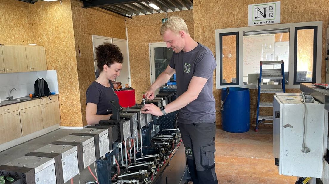 Twee medewerkers van New Born Rubber bij een apparaat