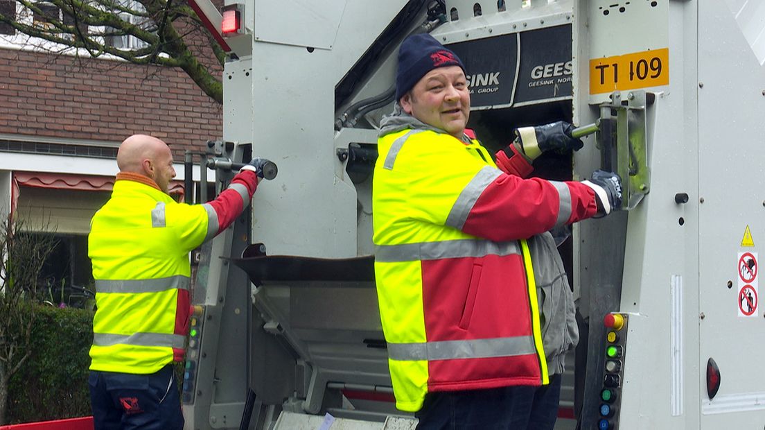 Edo achterop de vuilniswagen
