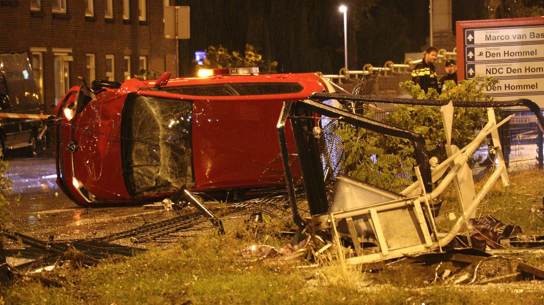 De auto ramde een reclamezuil en hek en eindigde op zijn zij.
