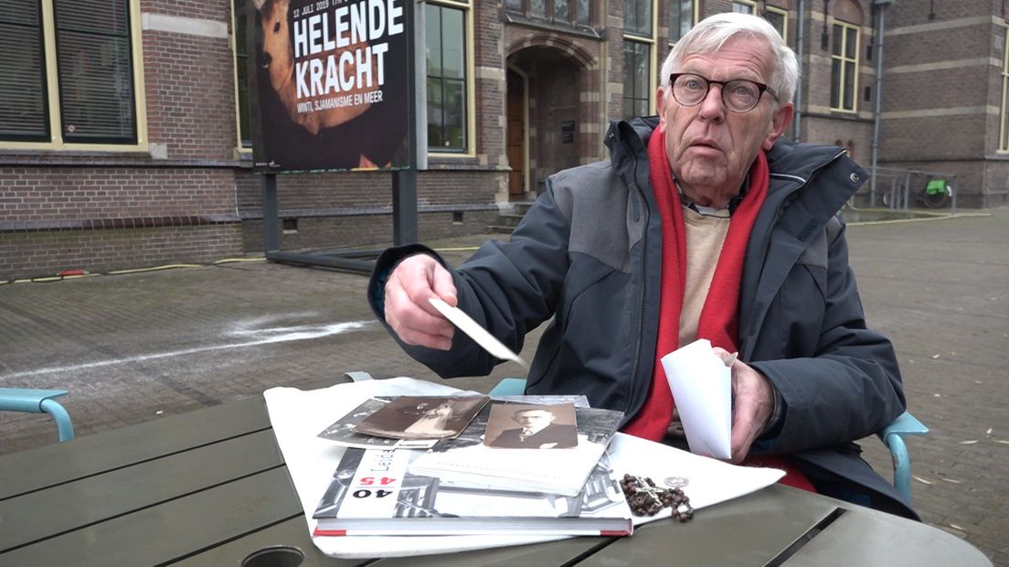 Chris van Beek bladert door oude foto's van zijn vader