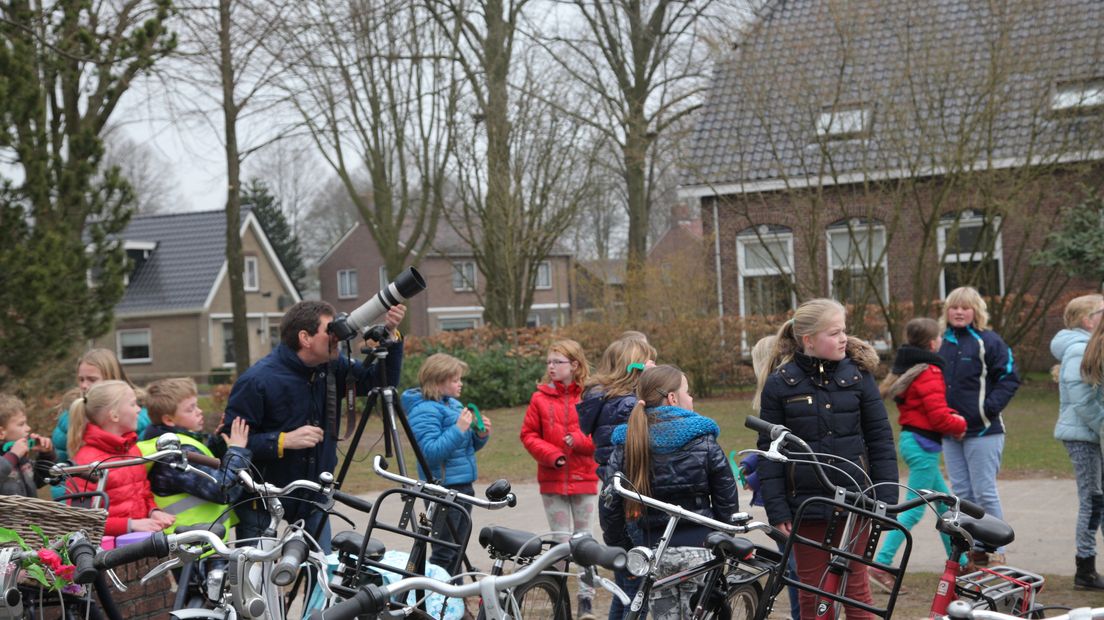 Leerlingen en leerkrachten van CBS De Wegwijzer in Westerbork kijken naar de verduistering.