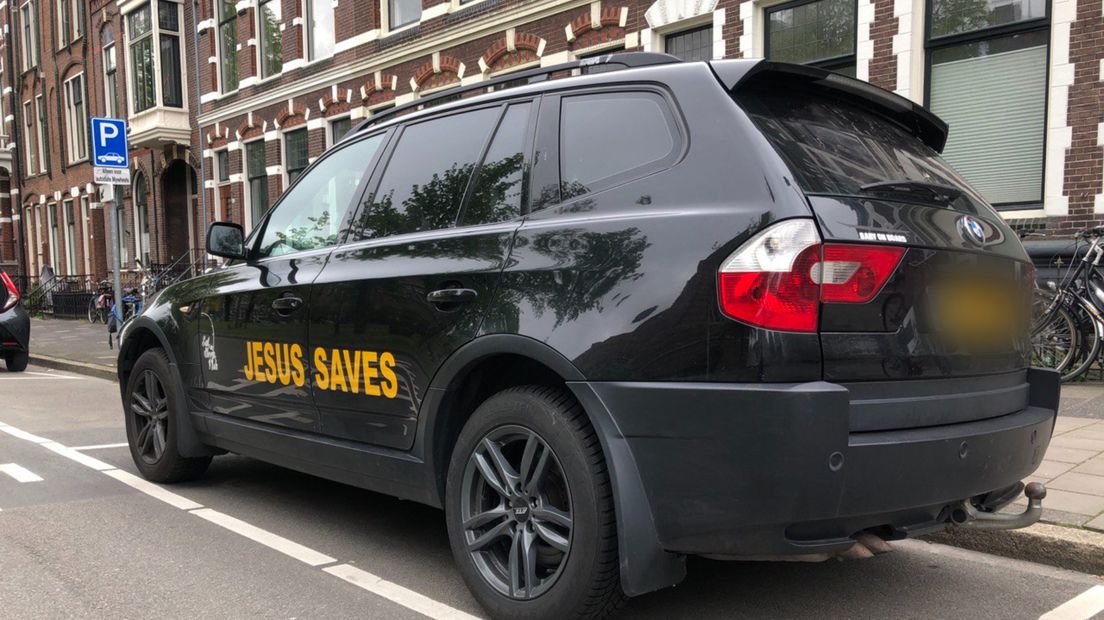 Op de auto van een van de demonstranten staat de boodschap 'Jesus saves'