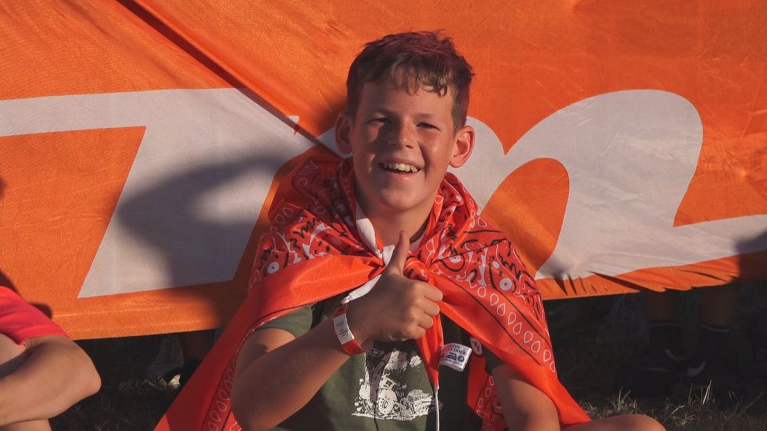 Een jonge touwtrekker heeft de rode 'boerenzakdoek' om zijn lichaam heen gewikkeld