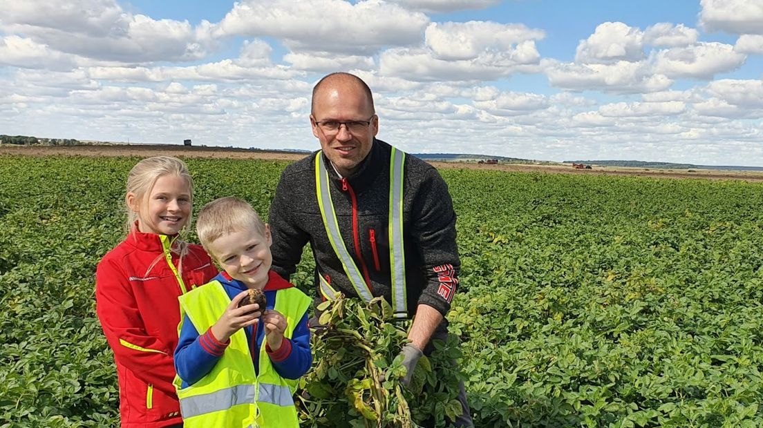 Willem Nammensma en kinderen op een aardappelveld in Oekraïne