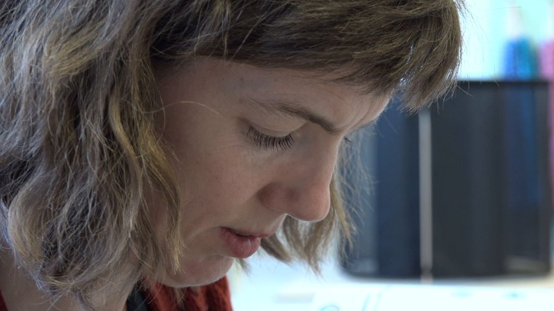 Kunstenaar Sara Vrugt is geconcentreerd aan het borduren