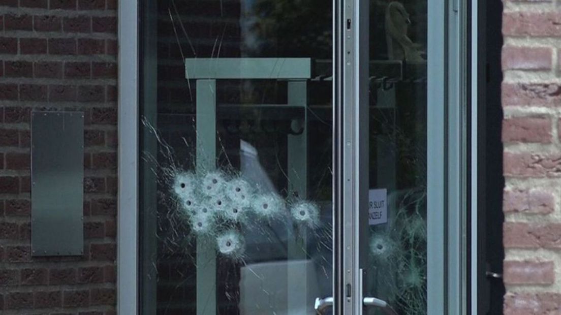 Kogelgaten in het glas bij de ingang van IrisZorg.