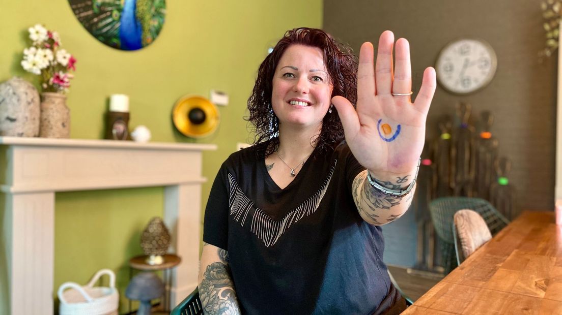 Ibolya Wessels met het logo van de stomavereniging op haar hand