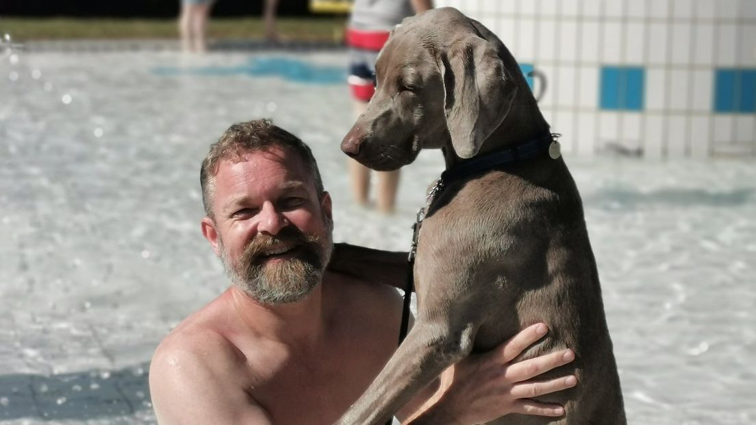 Een baasje met zijn hond in zwembad De Hoorn