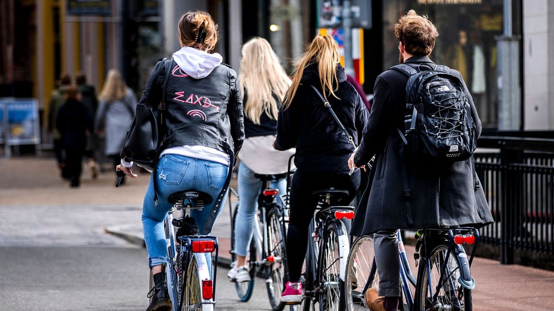 Studenten fietsen door de binnenstad van Groningen