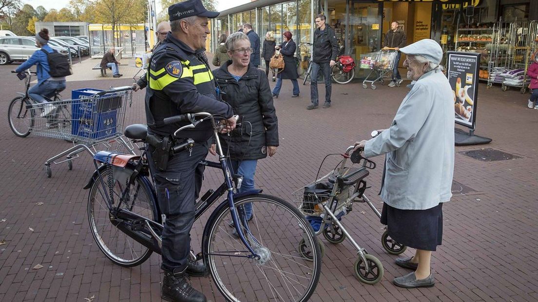 Een politieagent in gesprek met inwoners van Ter Apel