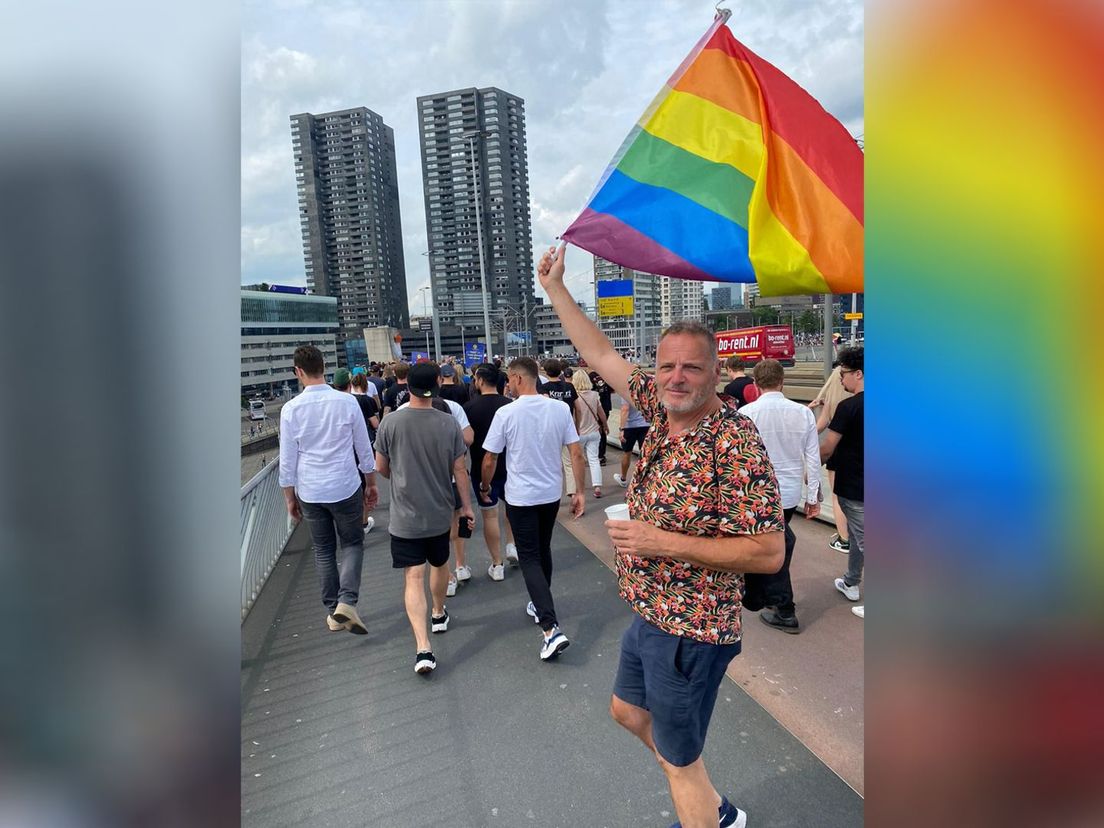 Jan op de Erasmusbrug met de regenboogvlag.