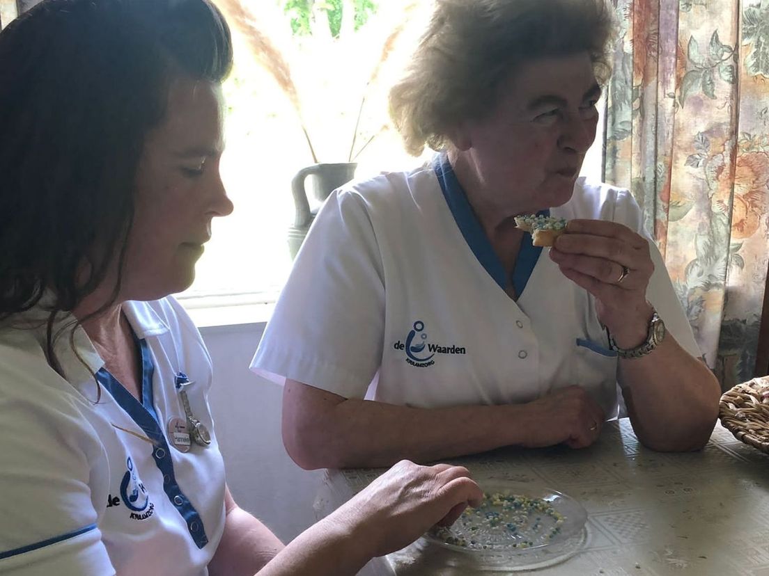 Hanneke en Corry eten een beschuitje met gele en blauwe muisjes mee.