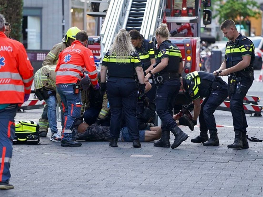 De verwarde man is met een ladder van het dak gehaald en overgebracht naar het ziekenhuis