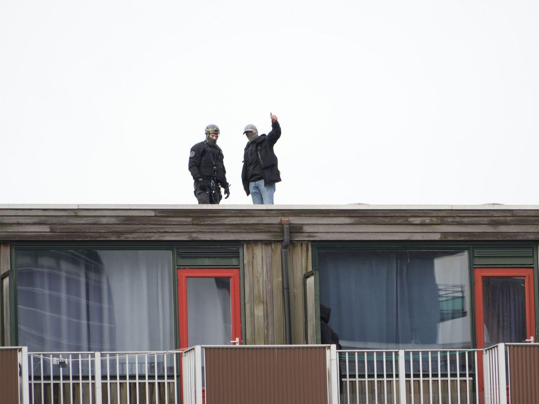 Politieagenten op het dak van het appartementencomplex