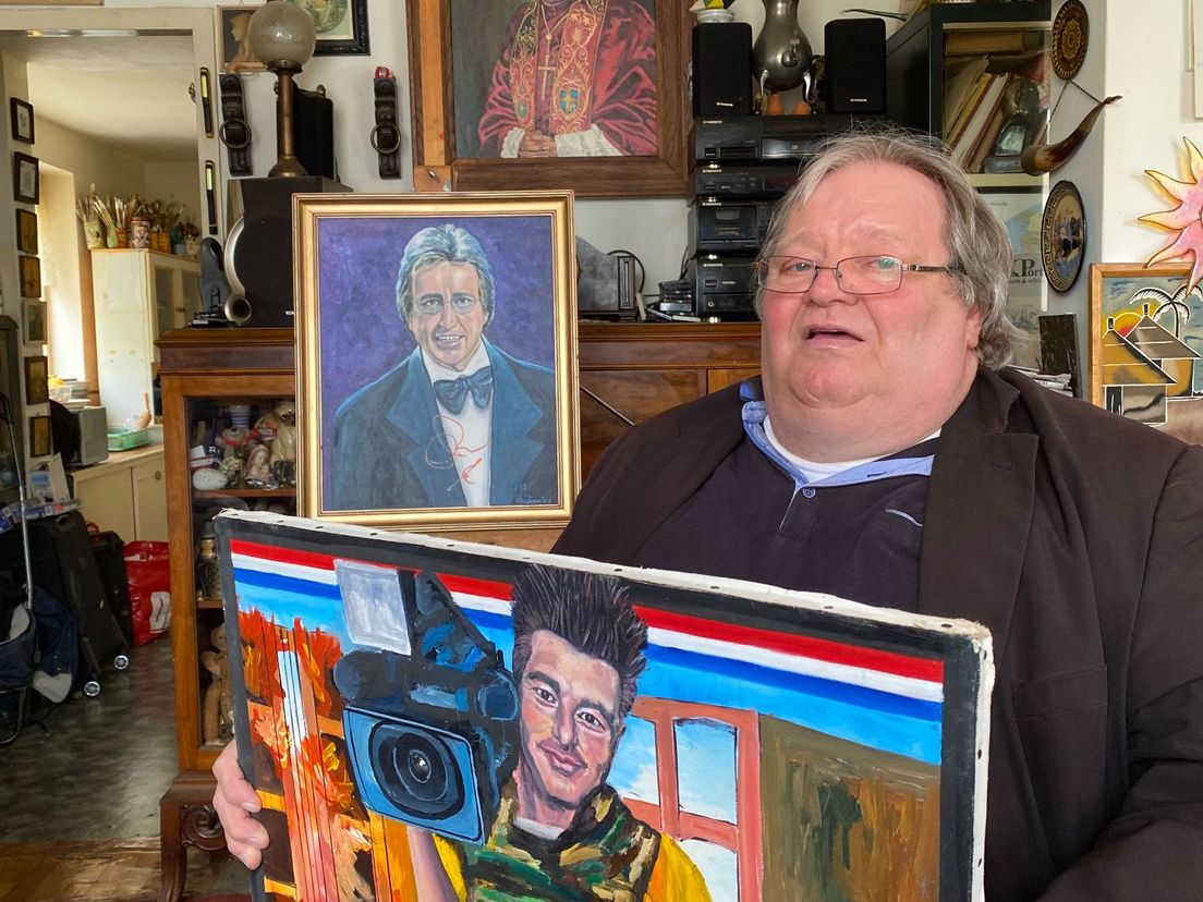 Schilder Rajkovics, met in zijn handen een schilderij van Stan Storimans.