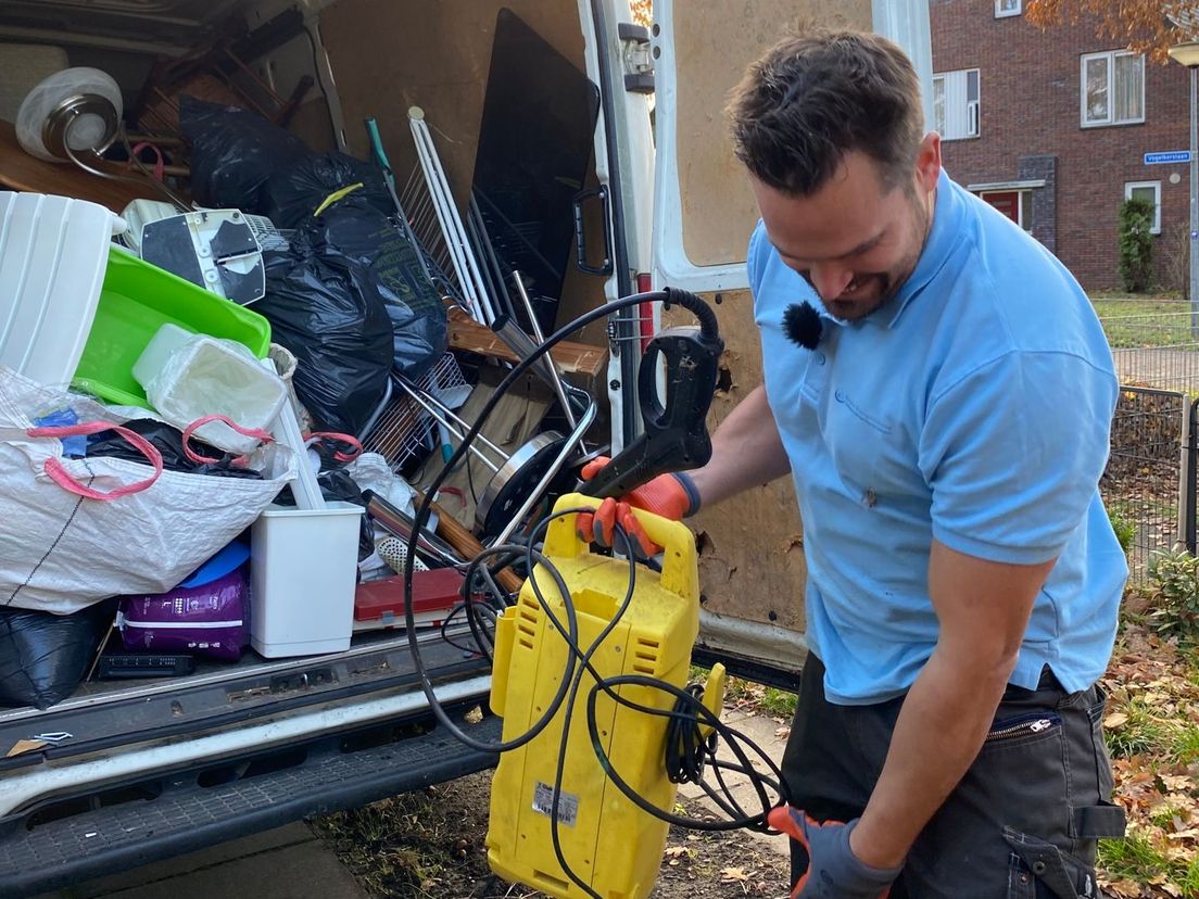 Ron Slaats bij zijn werkbus vol met spullen uit ontruimde woningen