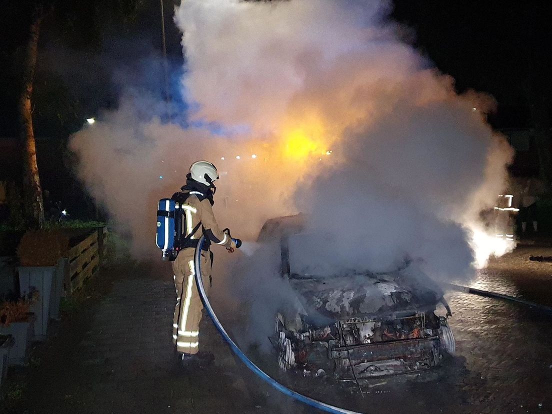 De brandweer blust de autobrand