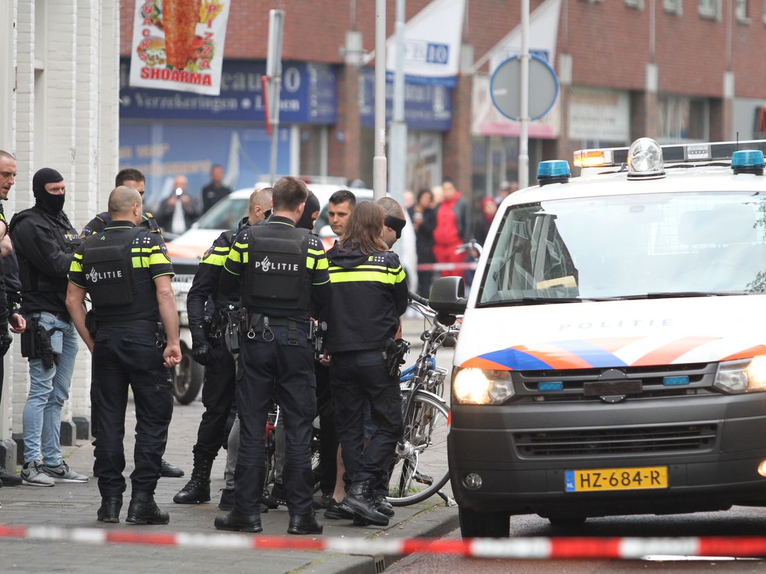 De politie met een van de arrestanten in de 2e Rosestraat