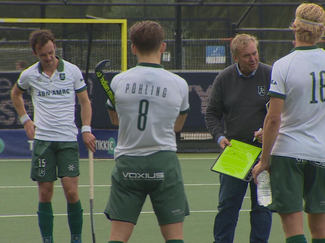 Hockeycoach Albert Kees Manenschijn te midden van zijn spelers