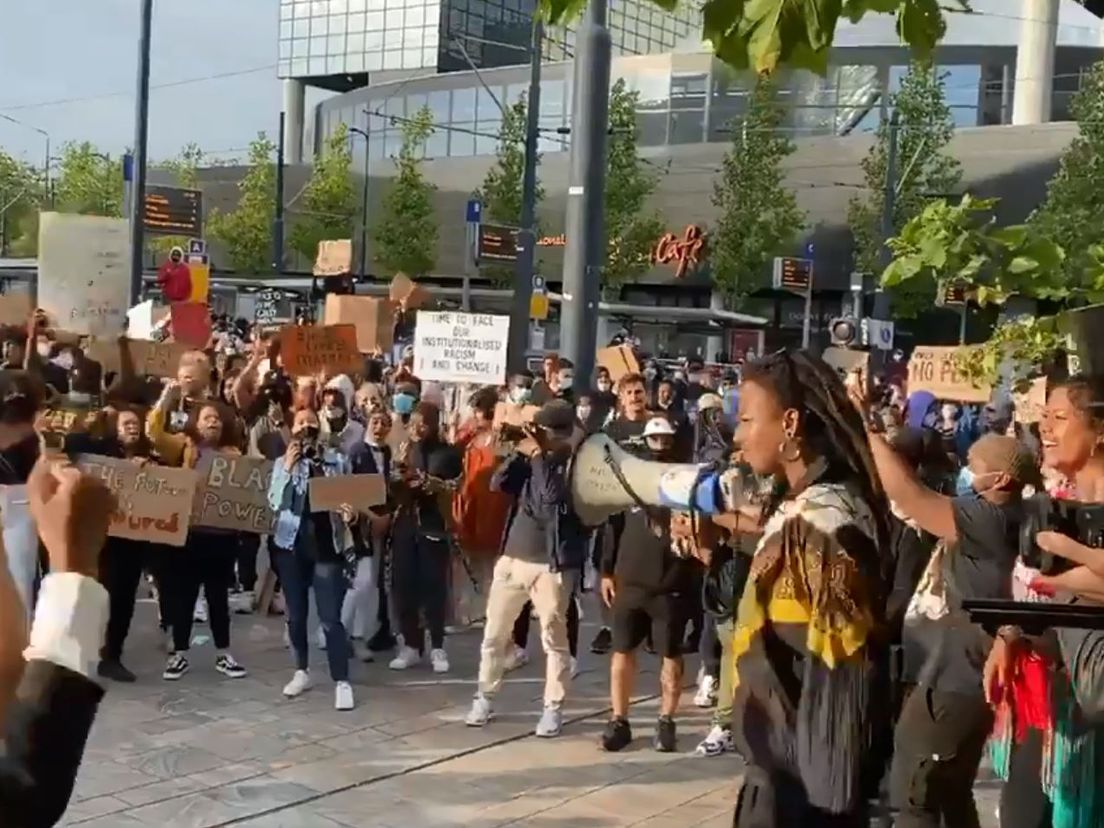 Demonstranten staan dicht op elkaar op het Kruisplein nadat ze weggestuurd zijn van de Erasmusbrug