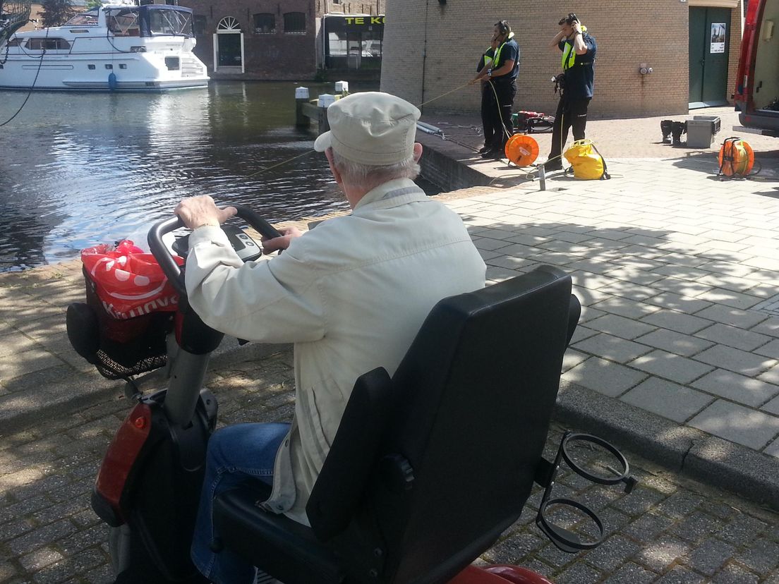 Een toeschouwer bij de duikactie van de brandweer in Schiedam