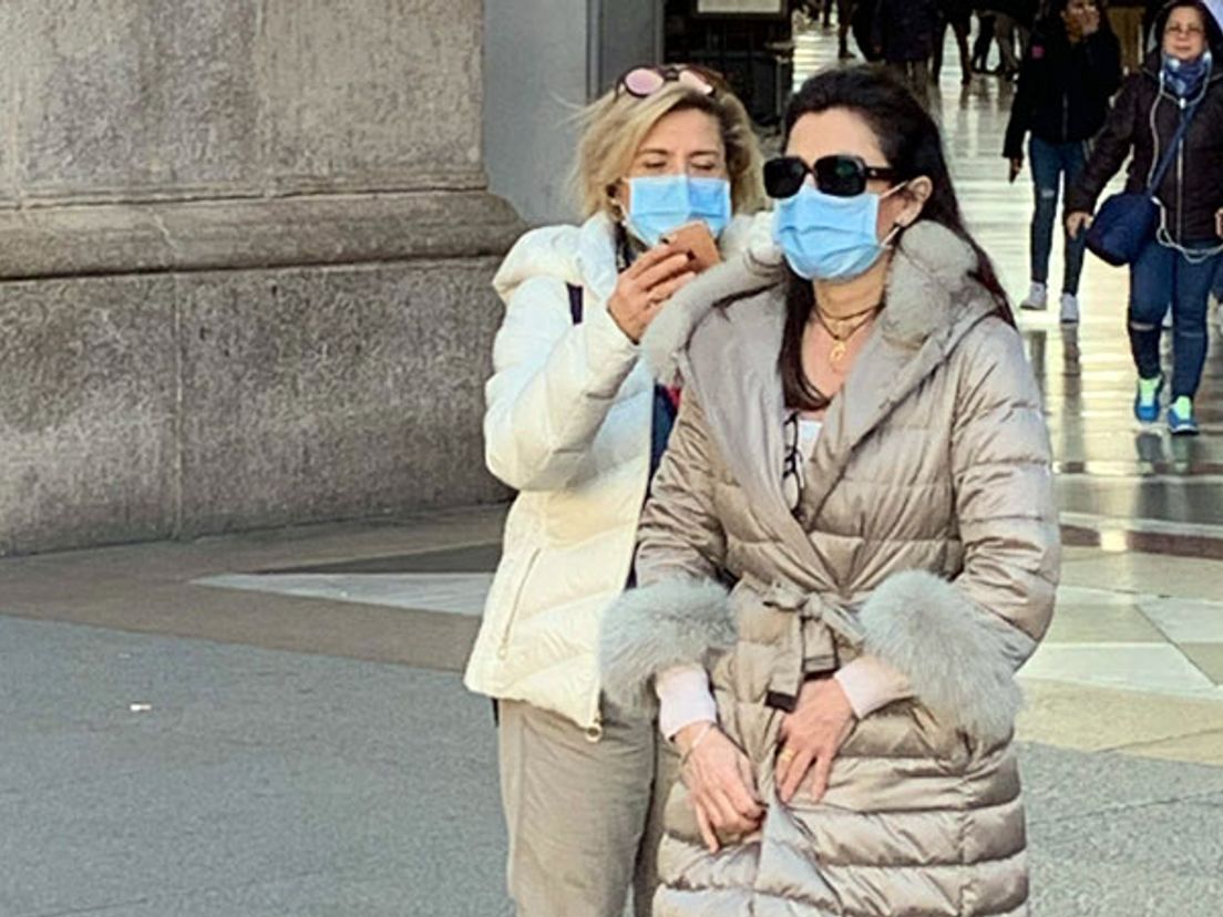 Mensen lopen met mondkapjes na de uitbraak van het coronavirus in Noord-Italië waar de Nederlandse patiënten besmet werden