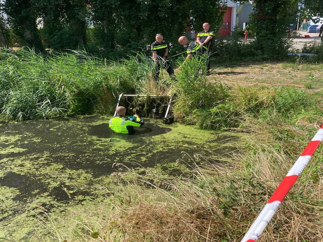 Agenten halen het pistool van de overval uit de sloot