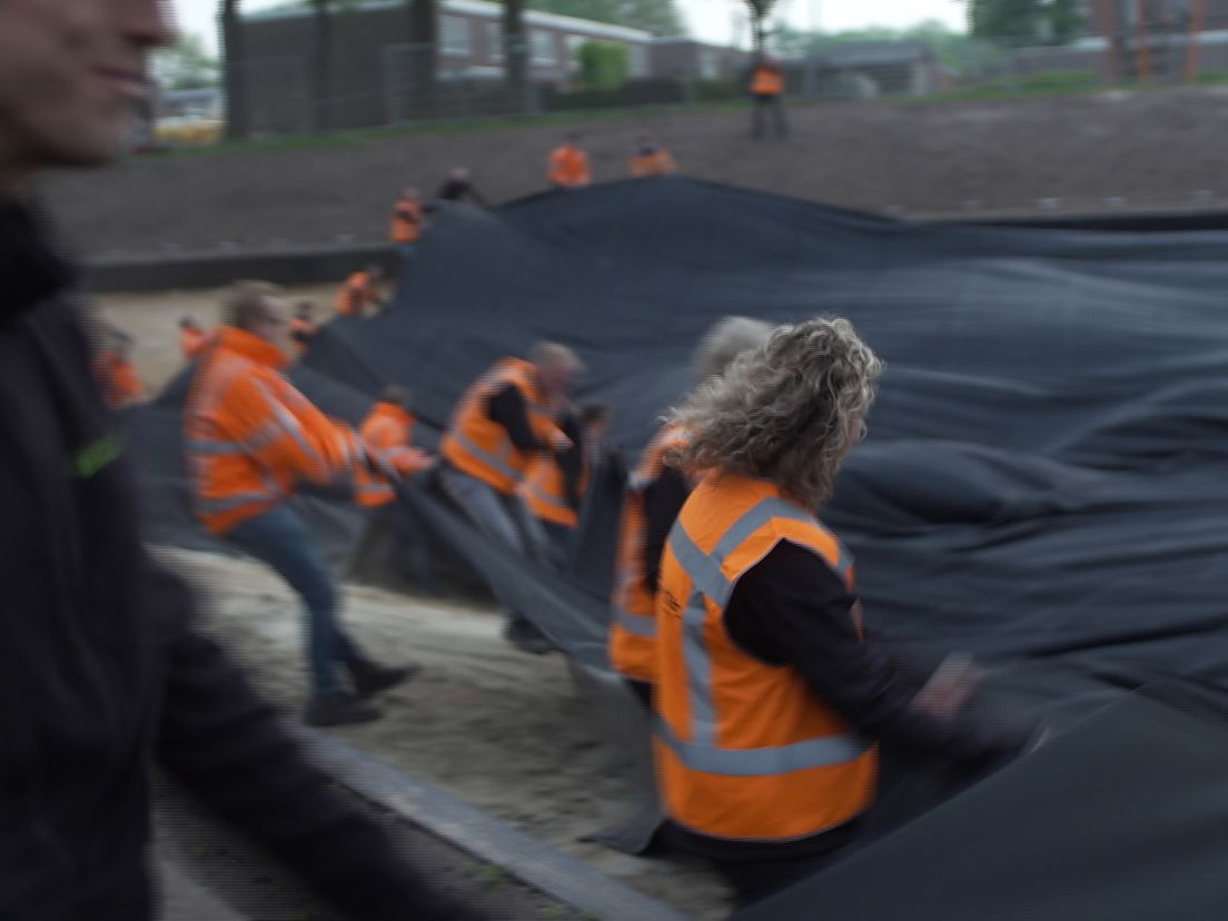 Kantoorpersoneel helpt mee met het spannen van het zeil (Rechten: Martijn Klungel/RTV Drenthe)