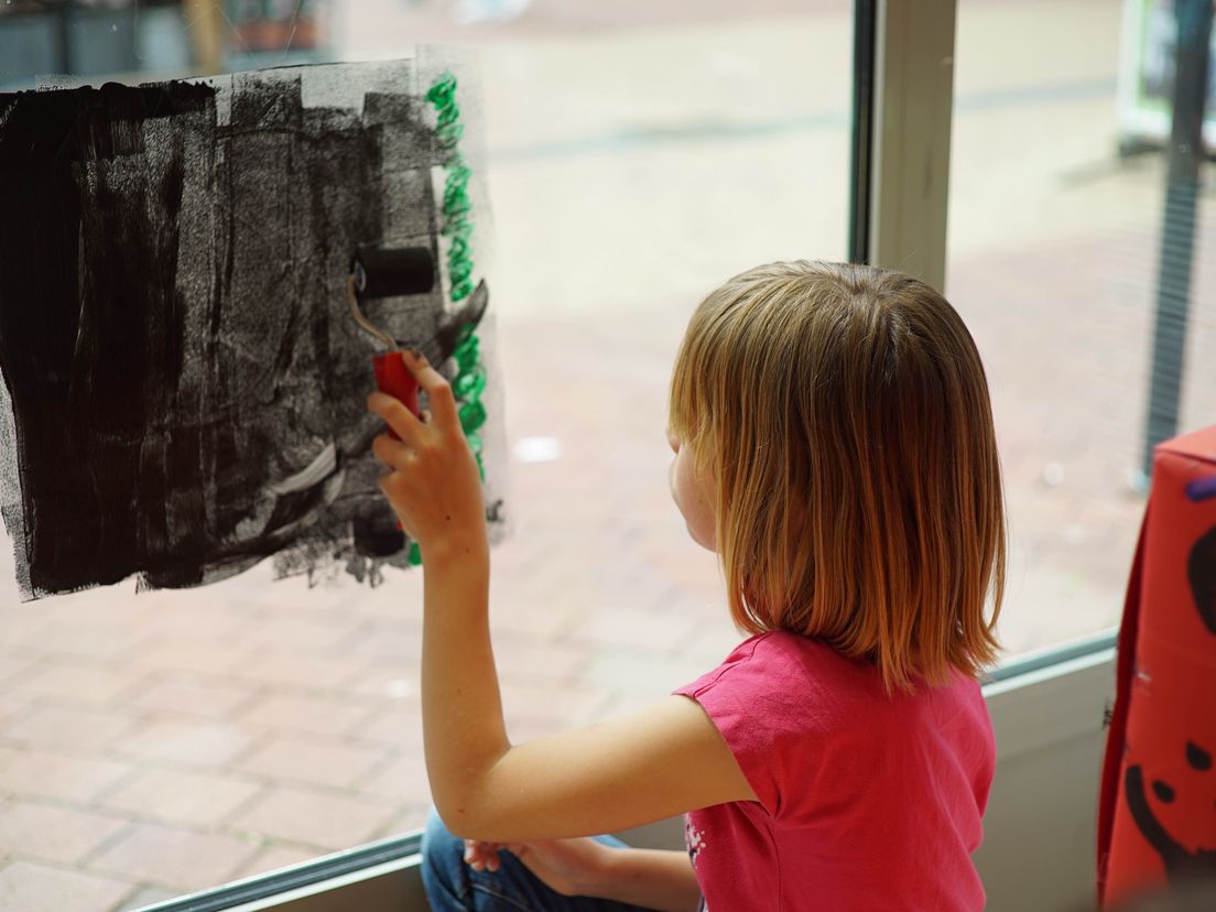 Een kind beschildert de ramen van het kennisatelier. (Rechten: Steven Ophoff/RTV Drenthe)