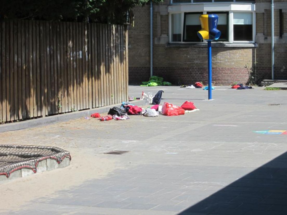 Op het schoolplein liggen de bezittingen van de leerlingen uitgestald om te worden opgehaald