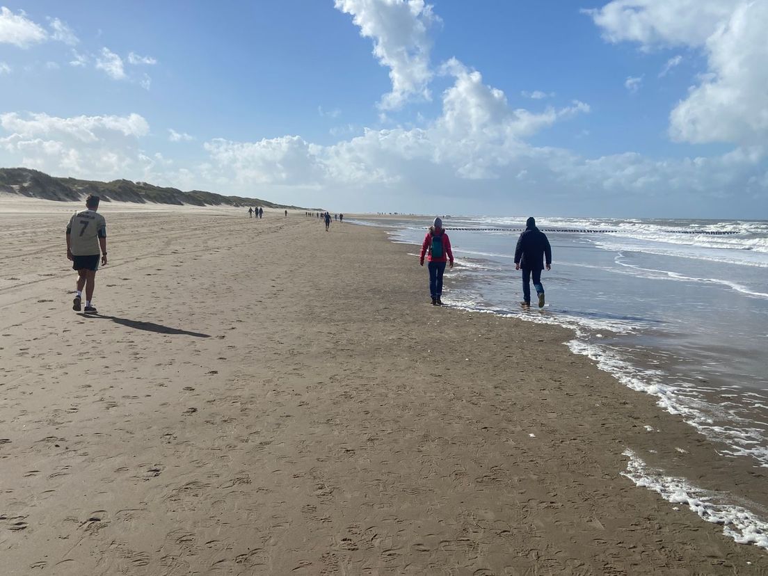 Het 'eindeloze' strand tussen Vrouwenpolder en Oostkapelle. In de staart van de marathon zijn er weinig medelopers. Wel zijn er strandbezoekers.