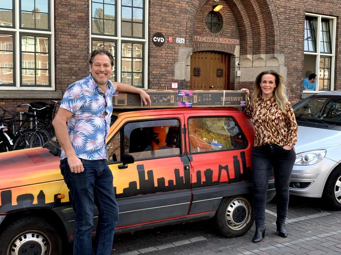 Sander de Kramer (links) en Danielle Veldhoven (rechts) met de thuisbioscoop op het autodak
