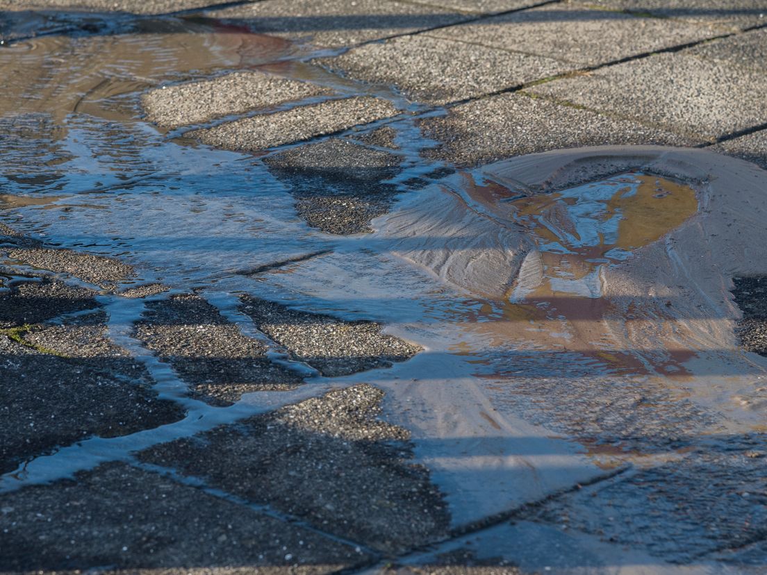 Water stroomt de straat op in Rotterdam-IJsselmonde