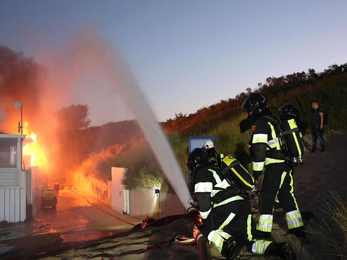 Brandweerlieden proberen te voorkomen dat de vlammen overslaan naar de duinen van Rockanje