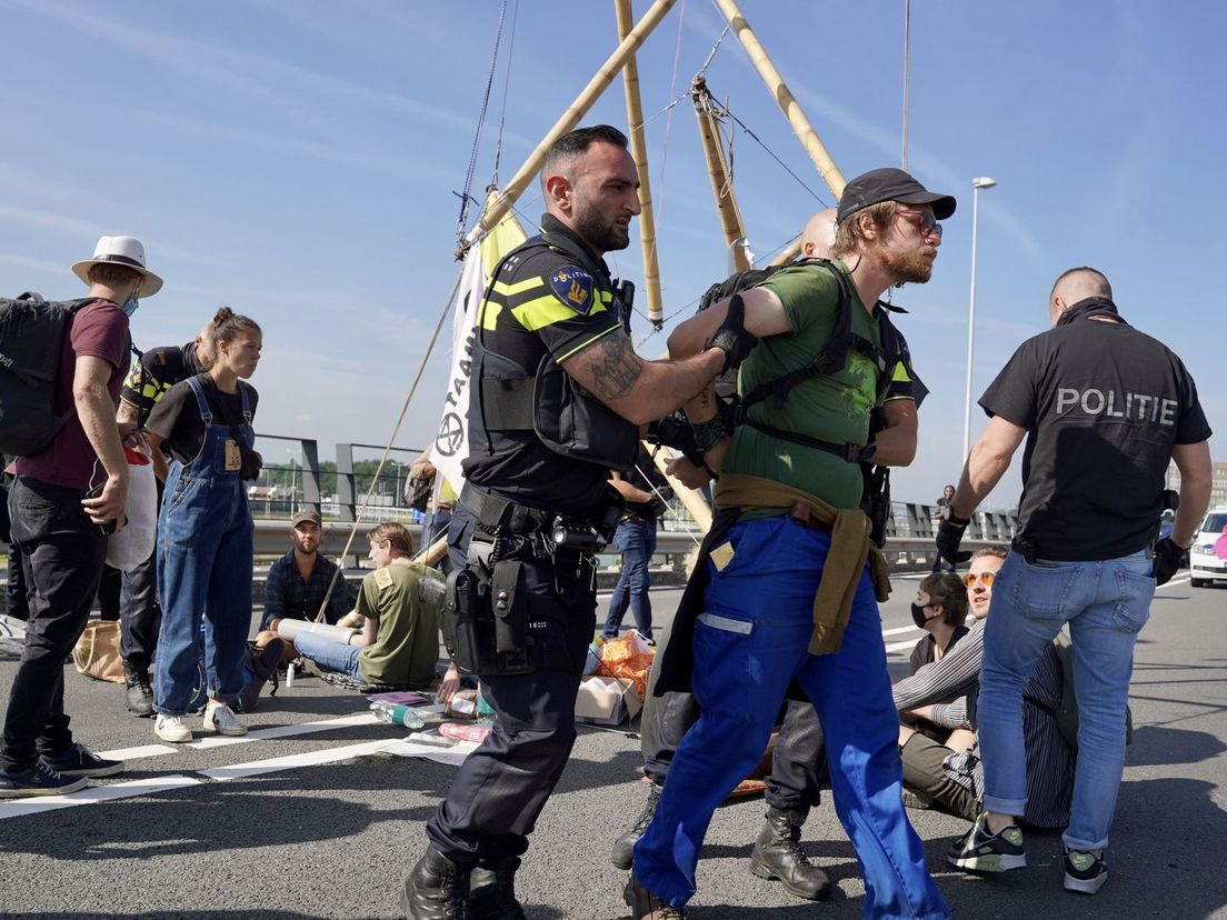 De politie houdt de activisten aan op het viaduct van de Vondelingenweg.