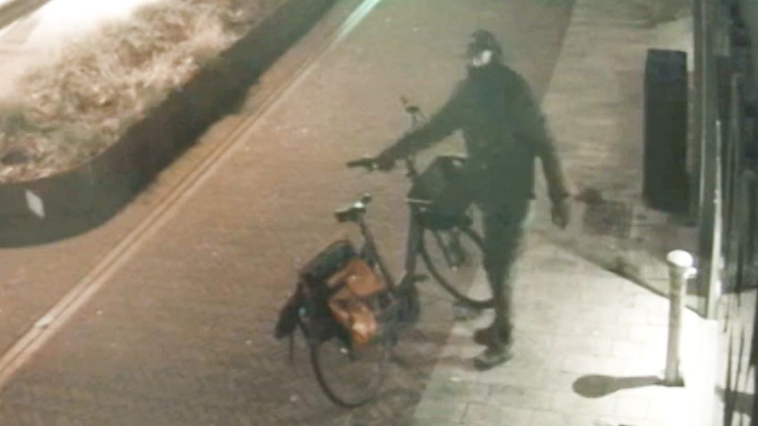 Deze man gooit meerdere keien tegen de ruit van een juwelier in Hengelo.