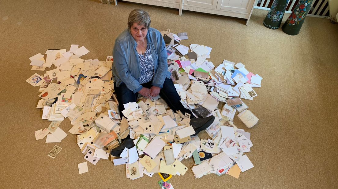 Hannie van Iwaarden tussen een fractie van haar verzameling geboortekaartjes